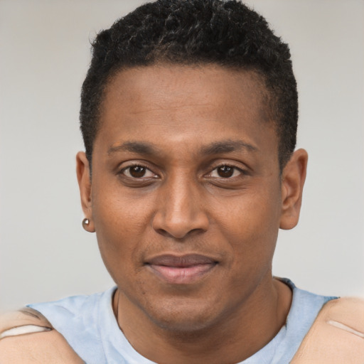 Joyful black adult male with short  black hair and brown eyes