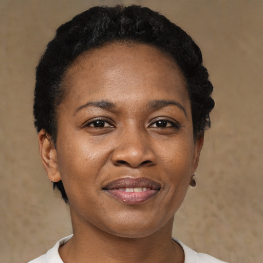 Joyful black adult female with short  black hair and brown eyes