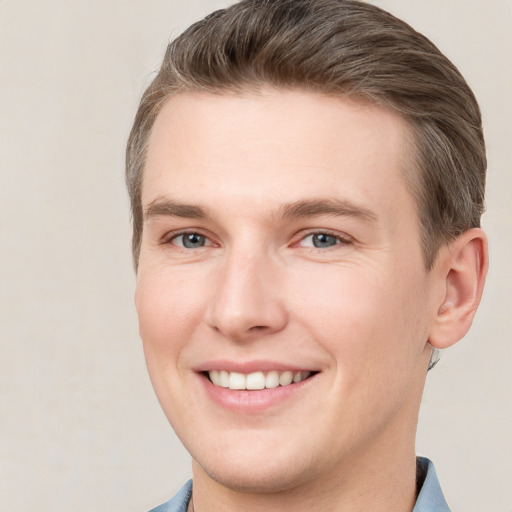 Joyful white young-adult male with short  brown hair and grey eyes