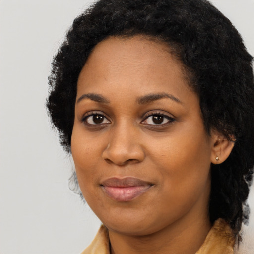 Joyful black young-adult female with long  black hair and brown eyes