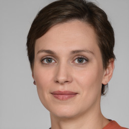 Joyful white young-adult female with medium  brown hair and grey eyes