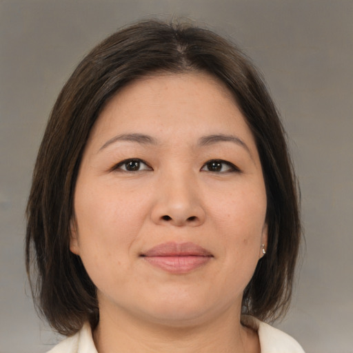 Joyful asian adult female with medium  brown hair and brown eyes