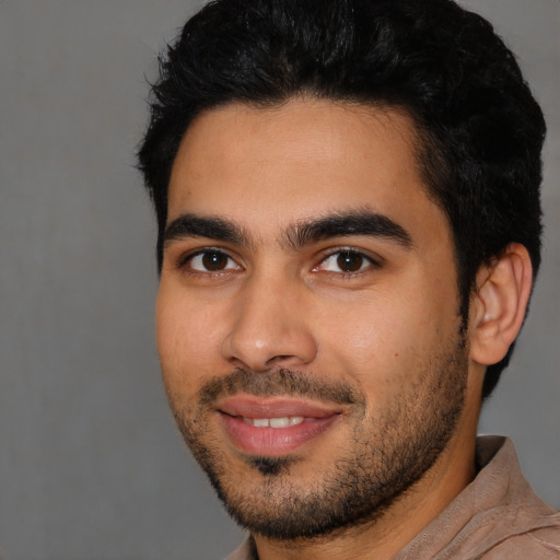 Joyful latino young-adult male with short  black hair and brown eyes