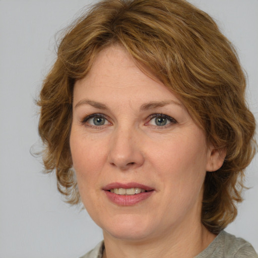 Joyful white adult female with medium  brown hair and blue eyes