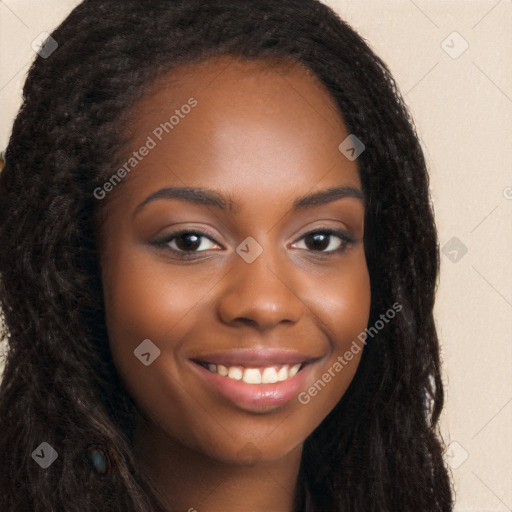 Joyful black young-adult female with long  brown hair and brown eyes