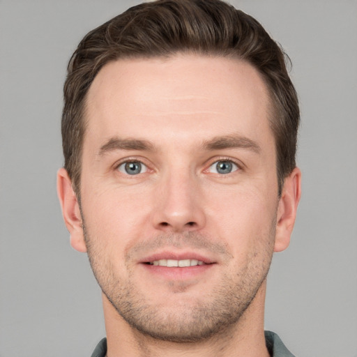 Joyful white young-adult male with short  brown hair and grey eyes