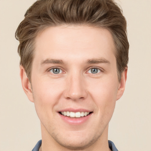 Joyful white young-adult male with short  brown hair and grey eyes