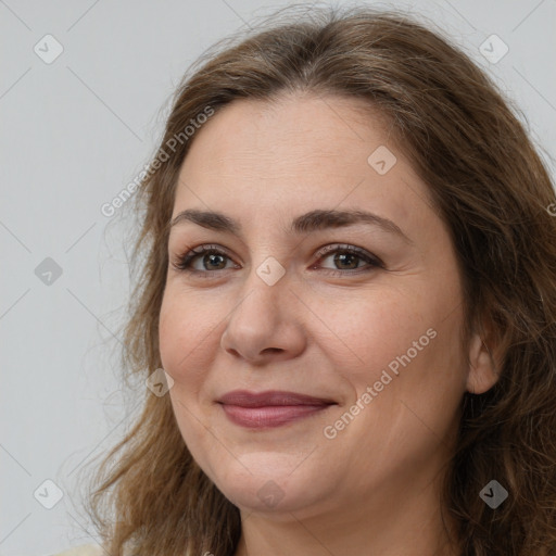 Joyful white adult female with long  brown hair and brown eyes