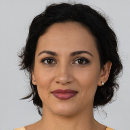 Joyful latino young-adult female with medium  brown hair and brown eyes