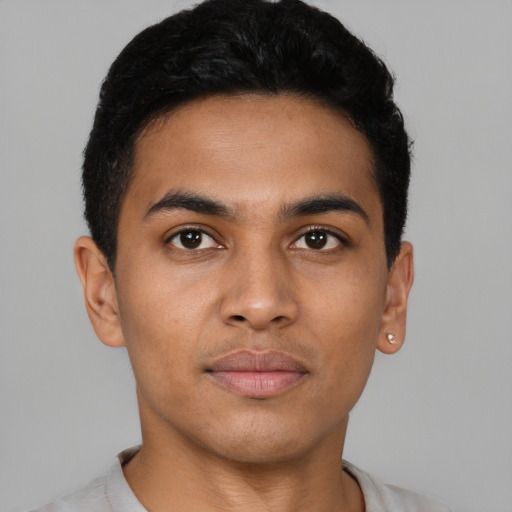 Joyful latino young-adult male with short  brown hair and brown eyes