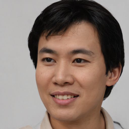 Joyful asian young-adult male with short  brown hair and brown eyes