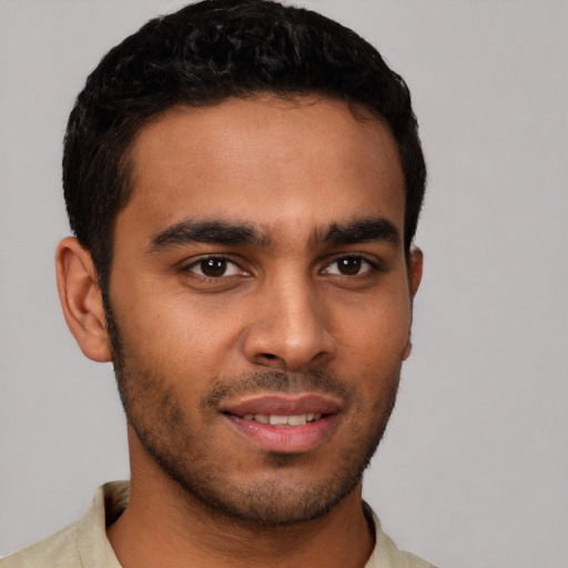 Joyful latino young-adult male with short  brown hair and brown eyes
