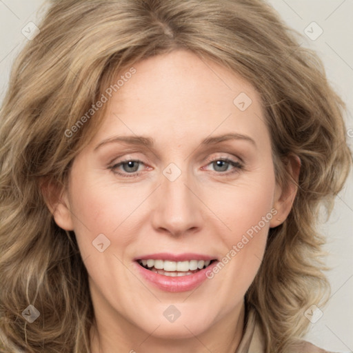 Joyful white adult female with long  brown hair and blue eyes