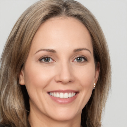 Joyful white adult female with long  brown hair and brown eyes