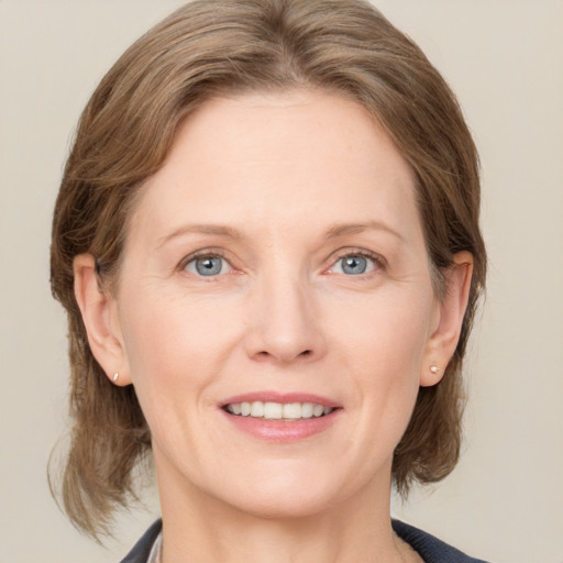 Joyful white adult female with medium  brown hair and grey eyes