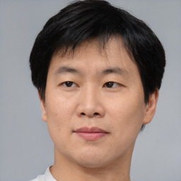 Joyful asian adult male with short  brown hair and brown eyes