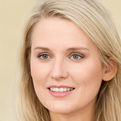 Joyful white young-adult female with long  brown hair and blue eyes