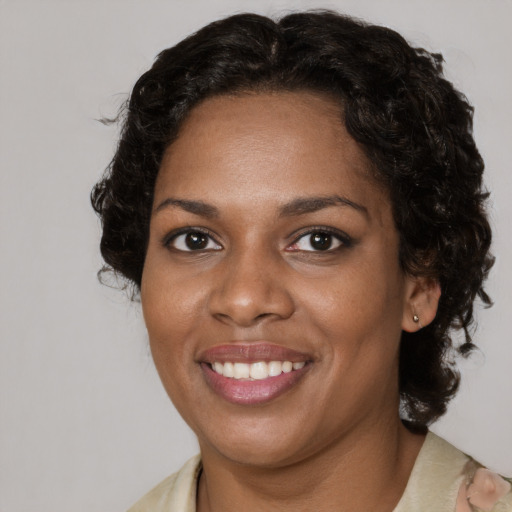Joyful black young-adult female with medium  brown hair and brown eyes