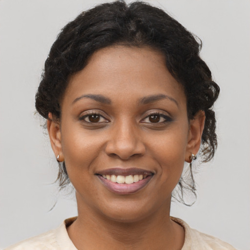 Joyful black young-adult female with short  brown hair and brown eyes