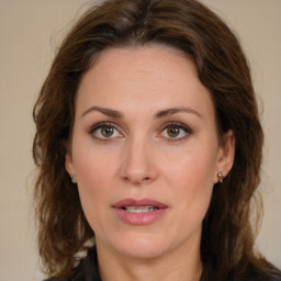 Joyful white young-adult female with medium  brown hair and green eyes