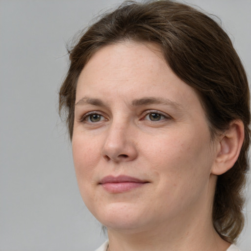 Joyful white adult female with medium  brown hair and grey eyes