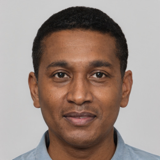 Joyful black adult male with short  black hair and brown eyes