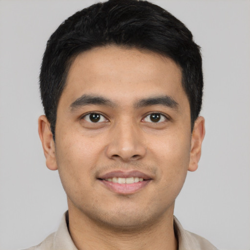 Joyful latino young-adult male with short  black hair and brown eyes