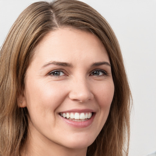 Joyful white young-adult female with long  brown hair and grey eyes