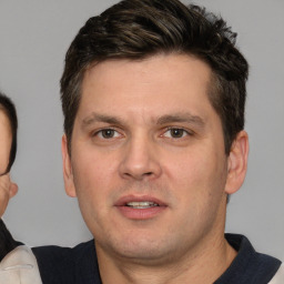 Joyful white young-adult male with short  brown hair and brown eyes