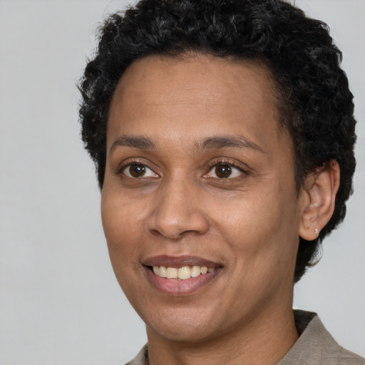 Joyful black adult female with short  brown hair and brown eyes