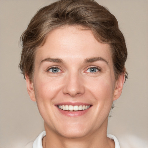 Joyful white young-adult female with short  brown hair and green eyes