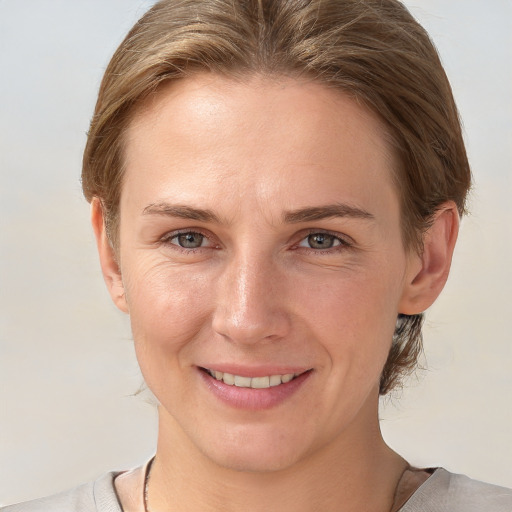 Joyful white young-adult female with short  brown hair and grey eyes