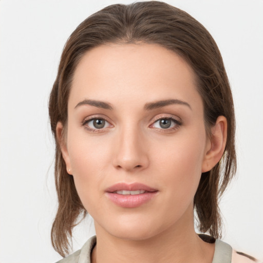 Joyful white young-adult female with medium  brown hair and grey eyes