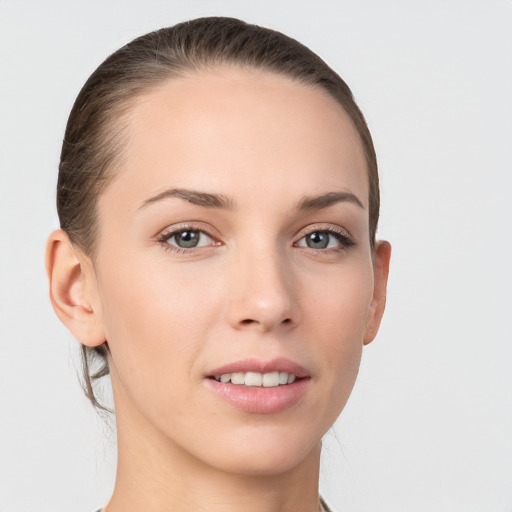 Joyful white young-adult female with medium  brown hair and grey eyes