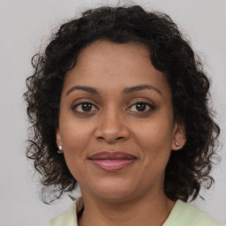 Joyful black adult female with medium  brown hair and brown eyes