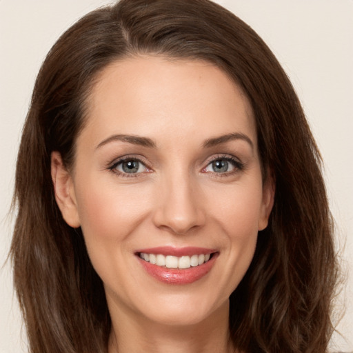 Joyful white young-adult female with long  brown hair and grey eyes