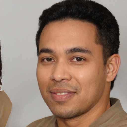 Joyful latino young-adult male with short  black hair and brown eyes