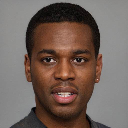 Joyful black young-adult male with short  black hair and brown eyes