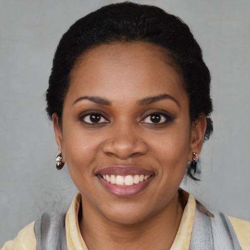 Joyful black young-adult female with medium  black hair and brown eyes