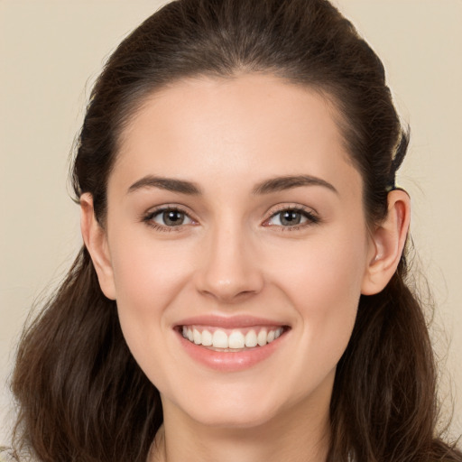 Joyful white young-adult female with long  brown hair and brown eyes