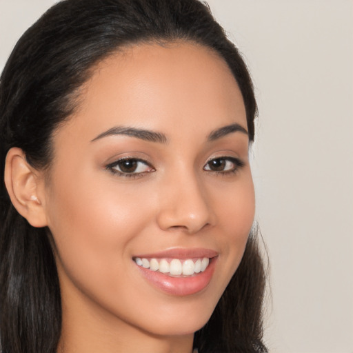 Joyful latino young-adult female with long  brown hair and brown eyes