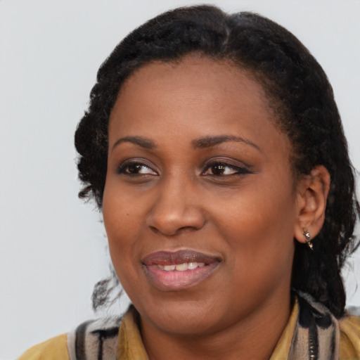 Joyful black young-adult female with long  black hair and brown eyes
