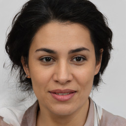 Joyful latino adult female with medium  brown hair and brown eyes