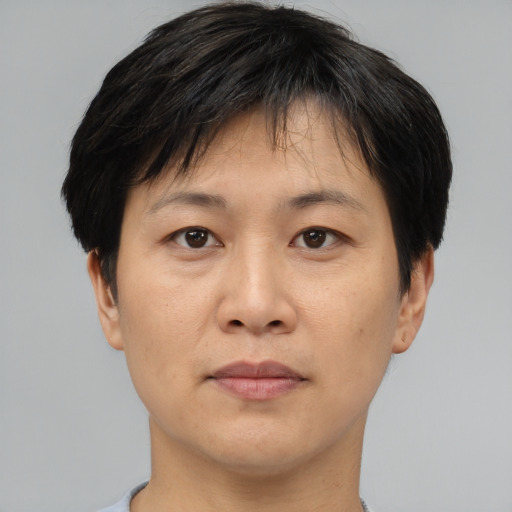 Joyful asian adult male with short  brown hair and brown eyes