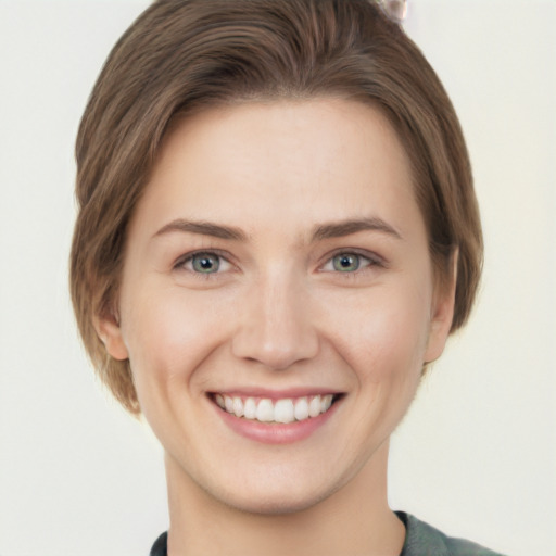 Joyful white young-adult female with short  brown hair and green eyes