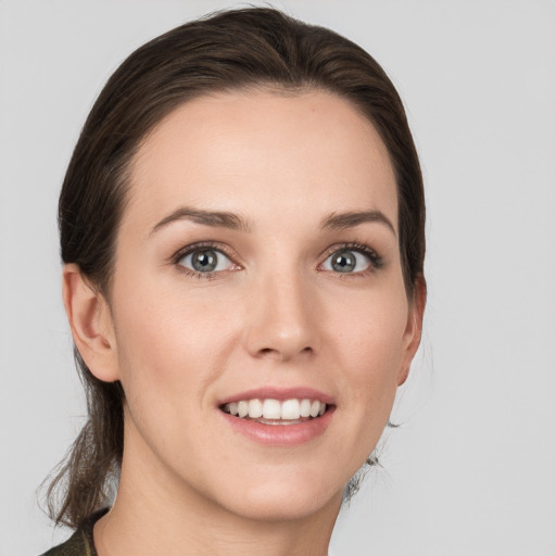 Joyful white young-adult female with medium  brown hair and grey eyes