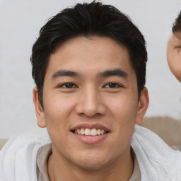 Joyful asian young-adult male with short  brown hair and brown eyes