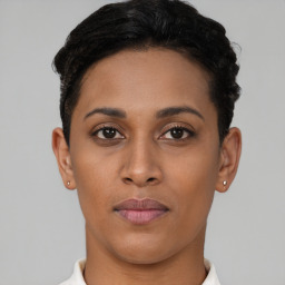Joyful latino young-adult female with short  black hair and brown eyes