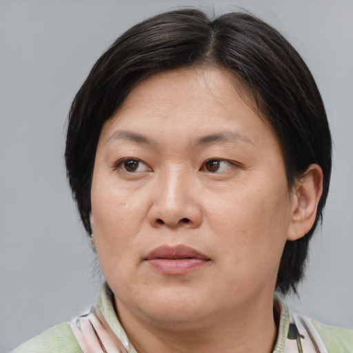 Joyful asian adult female with medium  brown hair and brown eyes