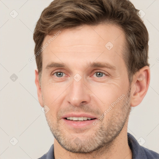 Joyful white adult male with short  brown hair and grey eyes